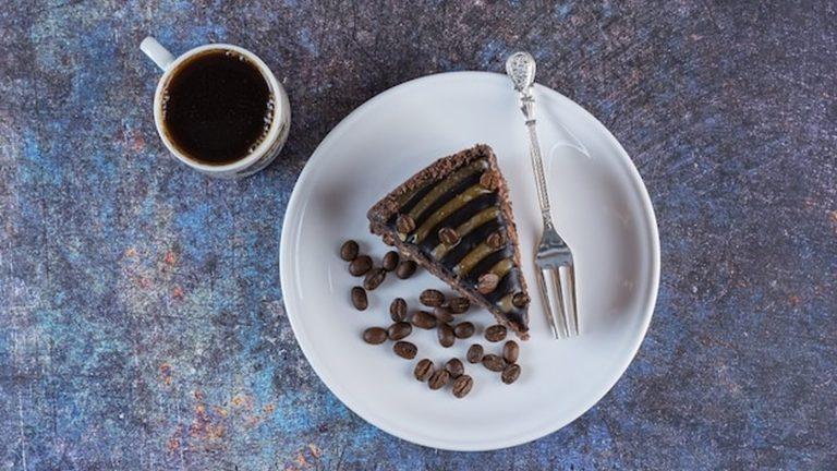 כוס קפה ופרוסת עוגת שוקולד על שולחן - Kaffee und Kuchen בבית קפה באינסברוק